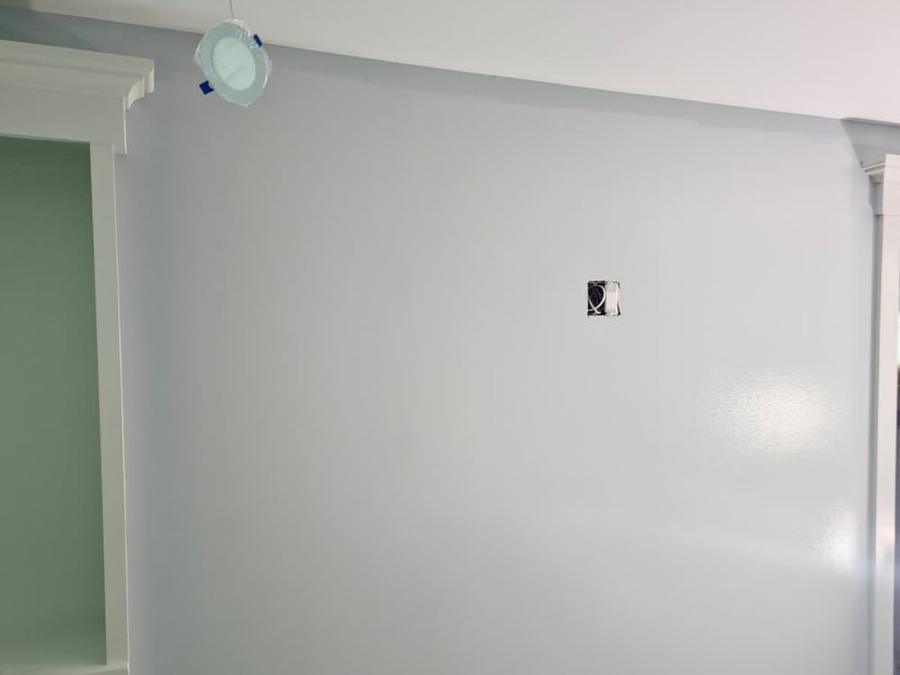 Light blue wall beside a painted built-in shelf